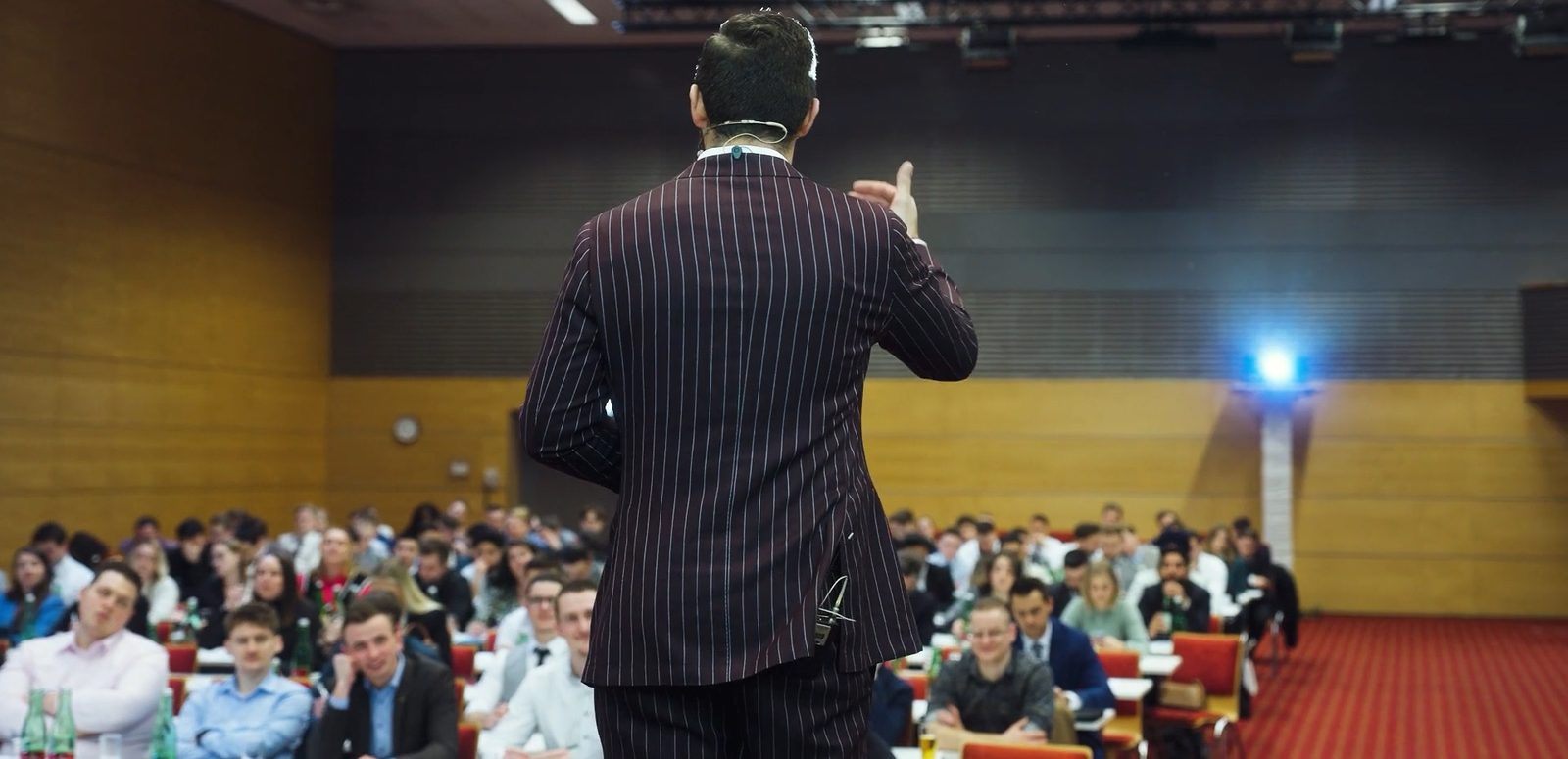 Benedikt Winter spricht auf einer Bühne vor mehreren hundert Menschen im Saal